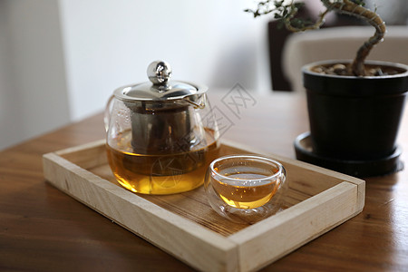 热茶杯 在木制桌上加茶壶饮料咖啡蒸汽桌子香气杯子玻璃液体毛衣草本植物流感图片