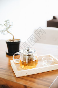 热茶杯 在木制桌上加茶壶饮料液体草本植物玻璃毛衣食物流感咖啡早餐桌子蒸汽图片