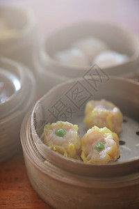 Dim sum 蒸汽在木篮子中国食品中排挤食物早餐汽船猪肉饺子餐厅午餐烹饪美食包子图片