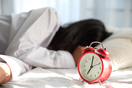 亚裔懒睡妇女睡在床上醒来时钟酒店苏醒女士唤醒女孩休息枕头警报房子女性图片