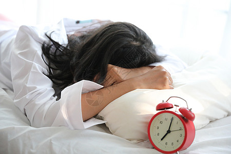 亚裔懒睡妇女睡在床上醒来时钟成人女性房子苏醒酒店警报喜悦休息房间微笑图片