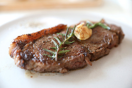 牛肉牛排和白桌上沙拉香料迷迭香食物牛肉蔬菜土豆木头炙烤烧烤肋骨图片