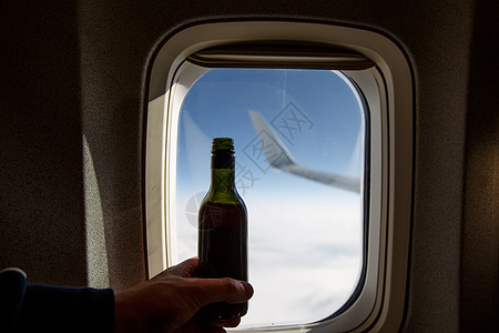 在门洞对面一瓶酒 飞机上酒精味的瓶子天空产品玻璃奢华旅行饮料喷射托盘小样运输图片