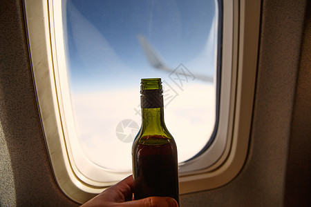 在门洞对面一瓶酒 飞机上酒精味的瓶子嘲笑托盘天空运输拉子航班木头产品商业奢华图片