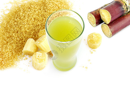 新鲜的甘蔗汁 新鲜的甘蔗汁和新鲜的甘蔗汁供饮料 甘蔗切块 甘蔗 白色背景中的砂糖黄棕色图片