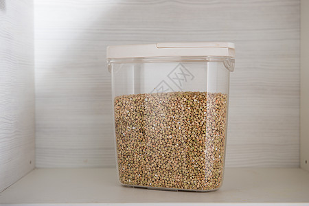 在一个透明的容器中用小麦储存木制谷物 以存放木制背景的谷类图片