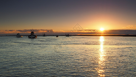 太阳落日反射在平静的海面上 渔船靠岸 苏福克Orford图片