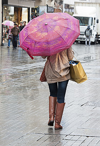 带着雨伞的女人走在街上图片