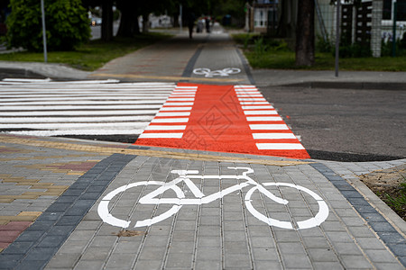 通过道路在地面上带有自行车符号的自行车道 现代城市的自行车道车道街道活动轮子路面环境沥青安全天空运动图片