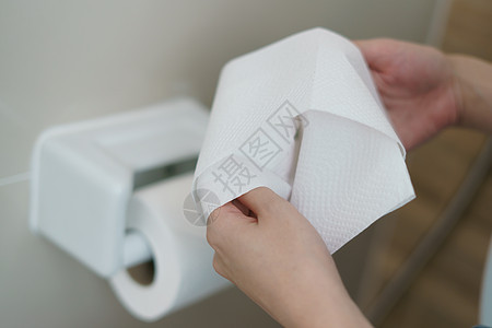 手拉着一卷卫生纸组织女性床单壁橱洗手间材料厕所产品座位家庭手指图片
