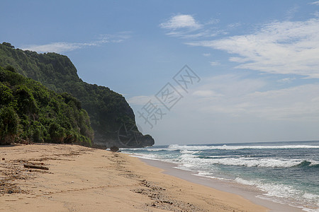 巴厘岛上的处女海滩 细黄沙 有海滩的热带天堂 背景是高悬崖 汹涌的海浪成排地逼近岸边 滚滚海浪中的海沫赭石场景天气季节娘娘腔墙纸图片