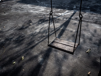 老的孤单木偶在日落时秋天挥舞着光和影子地面孤独公园阴影绳索树叶童年木头操场孩子们背景图片