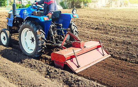 收割后 拖拉机上的农民耕种土地 研磨松散的犁地碎土 用于进一步播种栽培植物 机械化 农业技术的发展图片