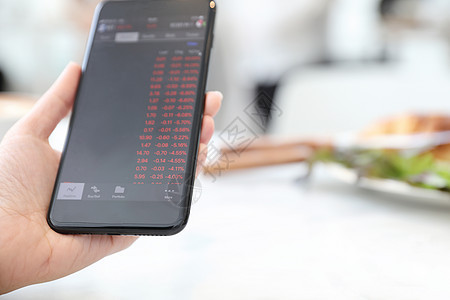 在咖啡店里用智能手机在线交易股票的女性手屏幕统计投资者互联网商业技术贸易数据图表金融图片
