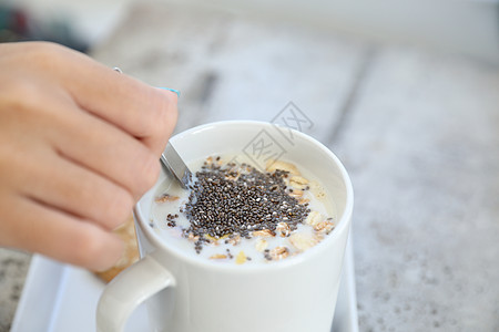 与妇女手食早餐一起 在牛奶中加奶杯的谷物玻璃杯子厨房燕麦水果豆浆小麦营养浆果甜点图片