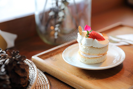 木制桌上的草莓蛋糕甜点海绵叶子糕点盘子鞭打水果食谱奶油派对桌子图片