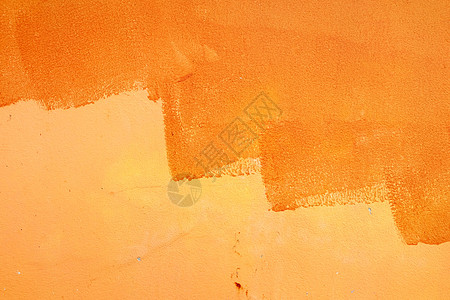 混凝土墙背景上未完成的橙色油漆图片