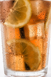 一杯加柠檬的冰茶绿色液体稻草玻璃水果黄色茶点薄荷白色棕色图片
