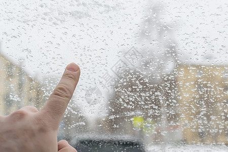 男人手指触碰汽车的冰玻璃图片