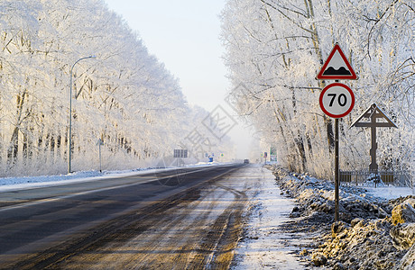 路牌和被雪覆盖树木包围的公路图片