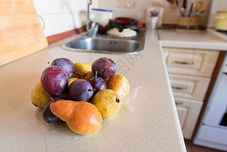 厨房的梨和李子橙子水果白色团体桌子季节紫色甜点黄色图片