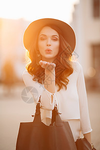 白发女人在购物后日落时 穿着帽子散步城市潮人夹克配件乐趣牛仔裤喜悦冒充女性女士图片