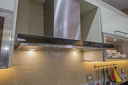 在豪华公寓的现代厨房炊具头罩烟囱瓷砖墙展示瓷砖排气扇奢华抽油烟机灰色设计橱柜背景图片