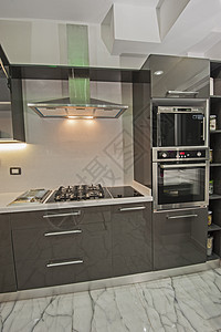 在豪华公寓的现代厨房器具架子白色柜台排气扇煤气灶炉灶炙烤橱柜风格背景图片