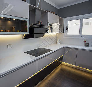 豪华公寓的现代厨房设计图条形台面抽屉窗户排气扇橱柜门木地板金属橱柜奢华背景图片