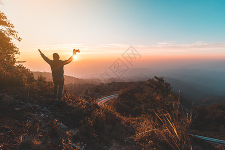 在山峰上举起手来 成功的人的休眠后盾理念援助肾上腺素挑战男人顶峰冒险图片