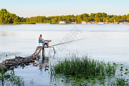 Dnieper河上的渔民香蒲渔夫天空钓鱼爱好绿色淡水男人活动蓝色图片