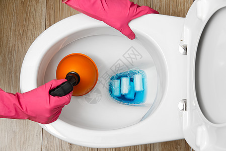 妇女清洁堵塞的厕所 破损的溢出马桶 家庭清洁服务概念图片