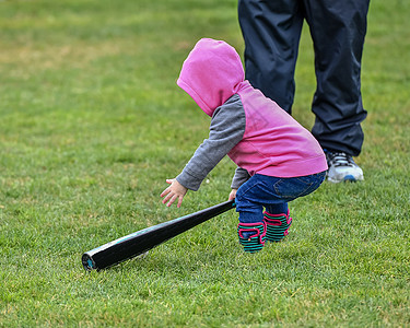 可爱的女婴玩棒球 打棒球和球运动蝙蝠儿童女孩探索孩子跑步游戏小姑娘背景图片