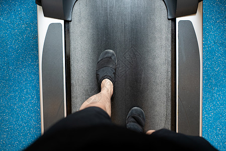 男子腿在健身房运动场上走路和跑步图片