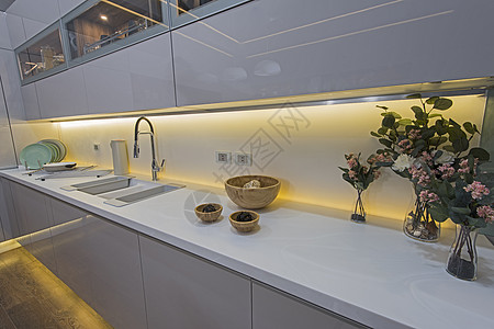 在豪华公寓的现代厨房橱柜白色龙头台面展示风格设计装饰品玻璃柜台图片