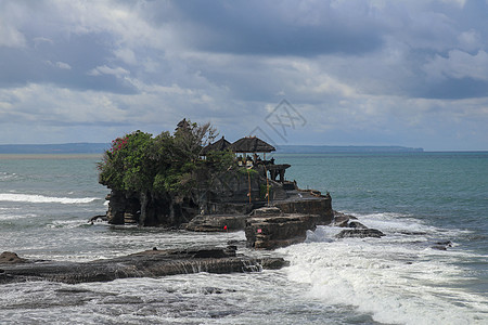 印度洋悬崖上海神庙的鸟瞰图 海浪拍打着巴厘岛海岸外的岩石悬崖 建在海中岩石上的印度教寺庙 悬崖顶上茂密的热带植被天空黑与白建筑日图片