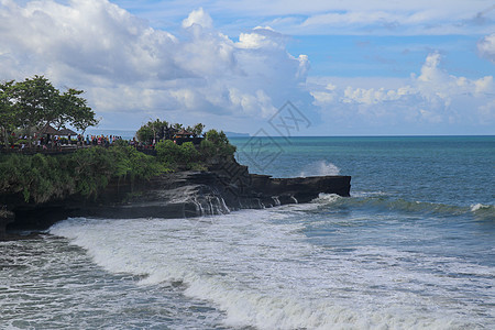 海滩是一个旅游景点 靠近山顶的海神庙 印度尼西亚巴厘岛附近的小海湾和沙滩 自然背景游客建筑历史悬崖旅行太阳文化热带宗教寺庙图片