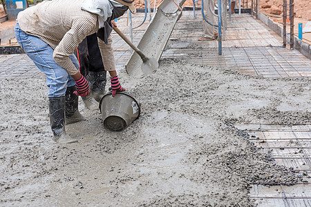 建筑工人为h提供新浇的混凝土混合料项目就业团队液体技术男人碎石管道金属房子图片