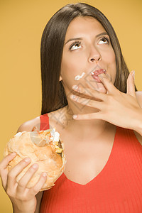 女人吃汉堡黄色女士食物手指面包女性营养饮食背景成人图片