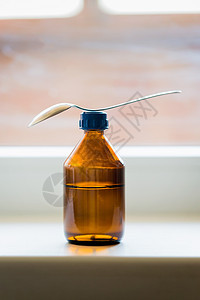 紧靠窗口的勺子鸡尾杯瓶瓶子液体流感桌子处方制药药店窗户玻璃疾病图片