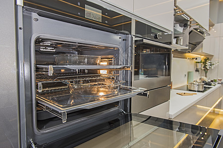 在一个豪华公寓中的现代厨房炉灶烤炉抽油烟机烤箱奢华台面设计平底锅控制橱柜排气扇展示图片