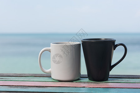 蓝色海背景的古董桌上几杯咖啡杯图片