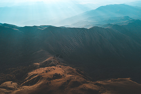 晨日的金光和薄雾的遮罩旅游森林太阳远足爬坡季节旅行风景顶峰草地图片