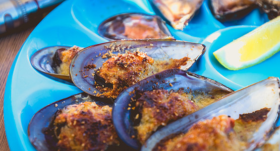 煮熟的牡蛎和贝贝 生在临近的桌边香菜食物生蚝贝类柠檬石头美食生活草药面包图片