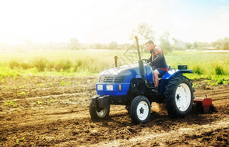 一位开着拖拉机的农民在田间劳作 栽培技术装备 在一家小型农业家族企业种植农作物 农业和农业 食品生产 研磨松动图片