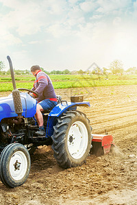 拖拉机上的农民耕种农田 土壤碾磨 破碎和混合 农业 种植有机食品蔬菜 疏松地表 耕种土地以进一步种植企业地面铣削栽培植物产业种植图片