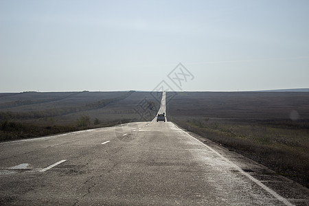 田地中间有标志的宽长公路白色旅行土地沥青黑色车道速度国家驾驶风景图片