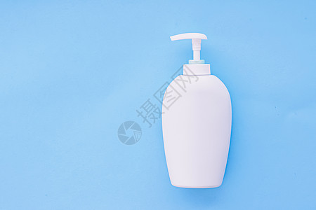 白标签化妆品容器瓶 作为蓝底产品模拟的蓝色面料平铺塑料奶油液体奢华润肤浴室淋浴消毒剂品牌图片