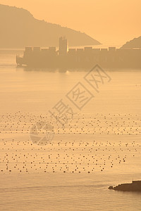 集装箱船在前面穿过拉斯佩齐亚湾海面背景图片