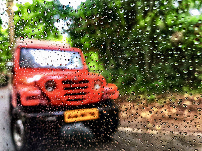 车窗上的雨滴 其背景对汽车和森林的视线模糊图片
